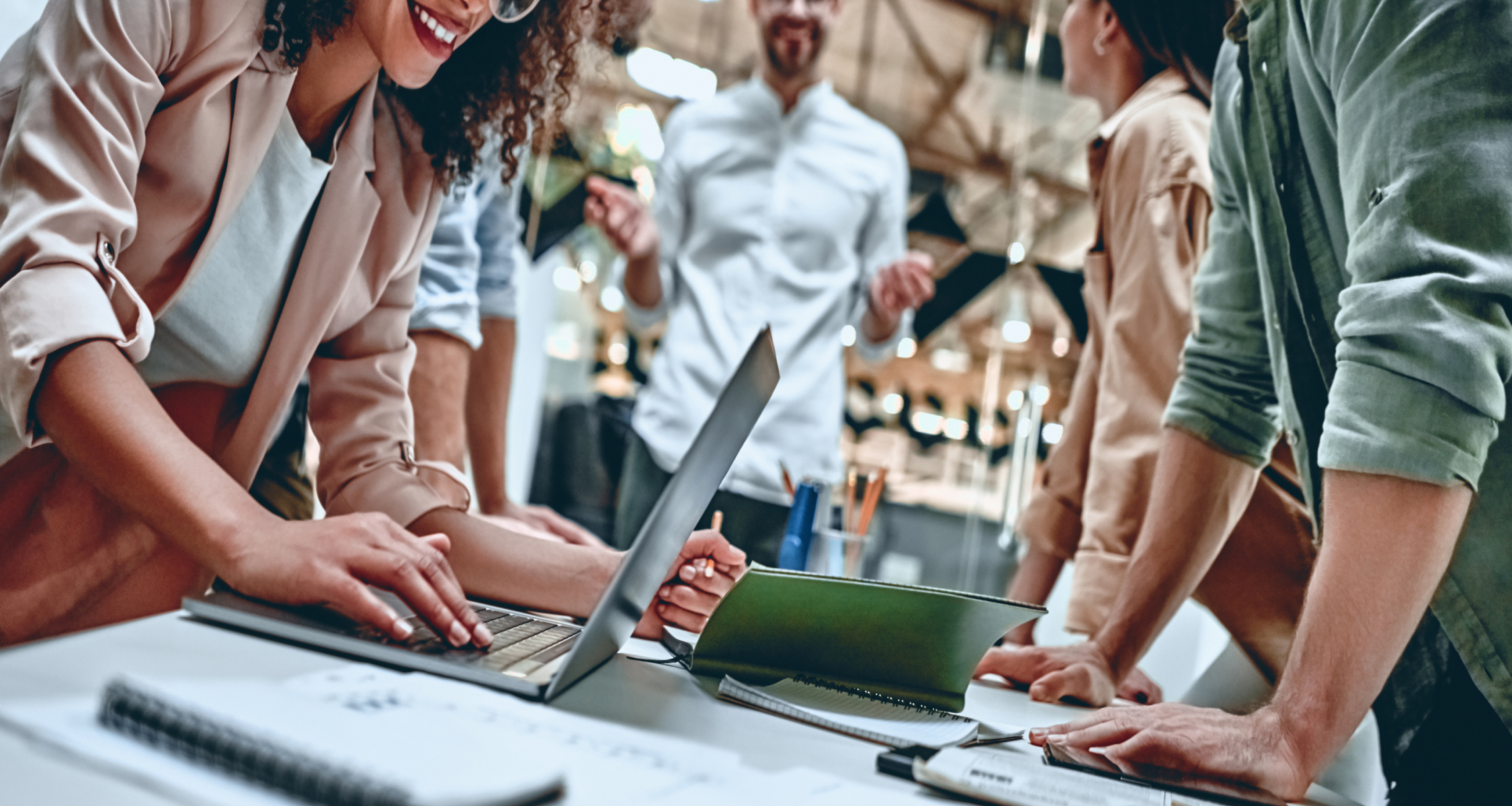 Close up shot of an office meeting with a woman using a laptop