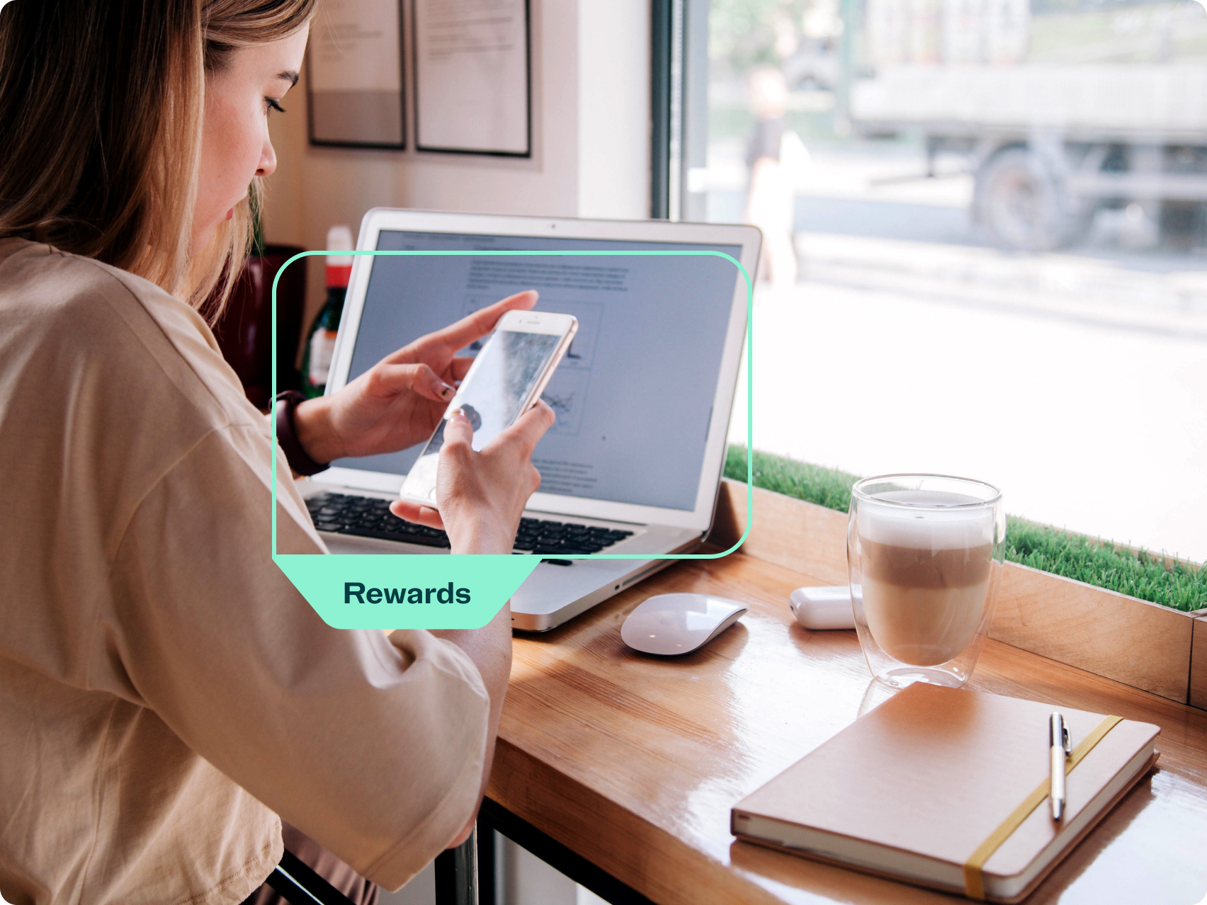 Woman using a mobile phone in front of a laptop