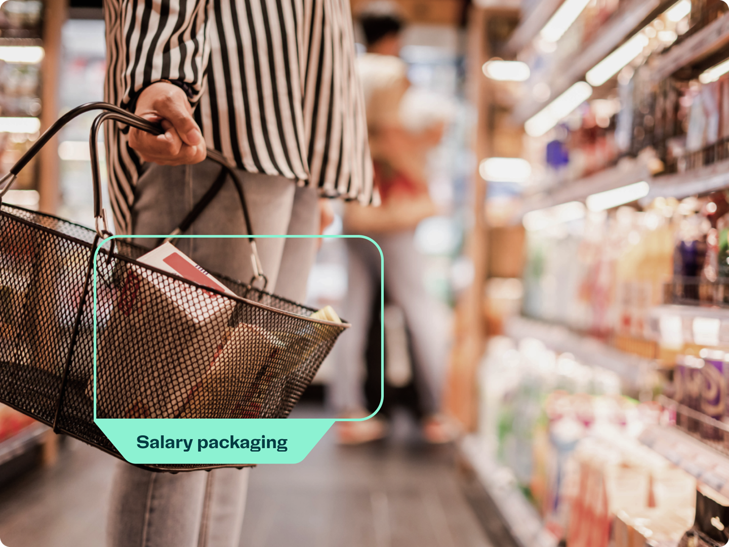 Person holding shopping basket in supermarket aisle