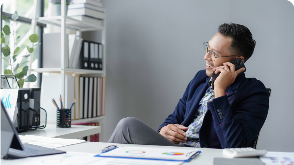 Smiling man on phone at desk