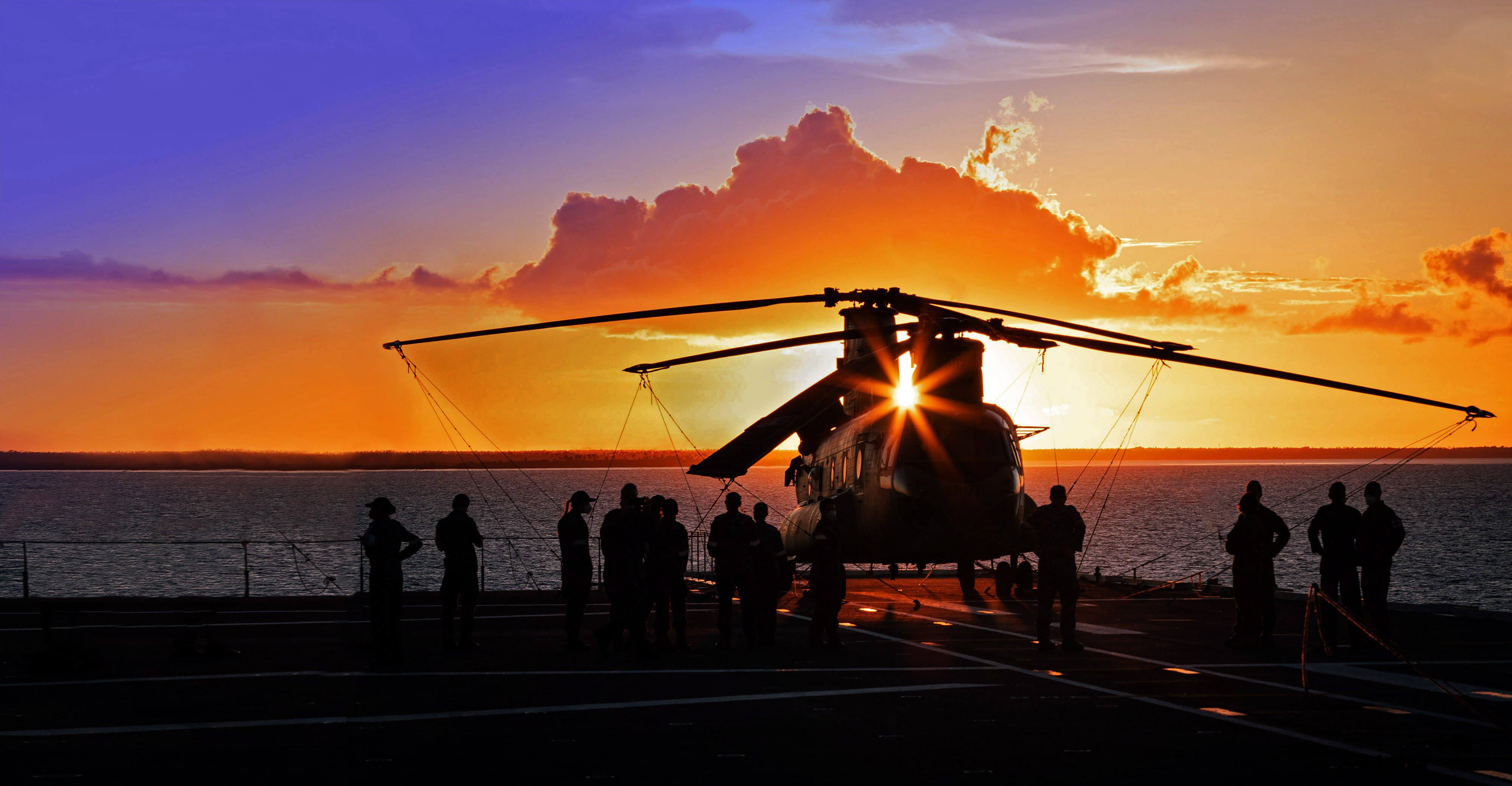 Helicopter on ship in front of a sunset