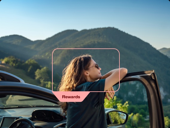 Person leaning from a car door with mountain views