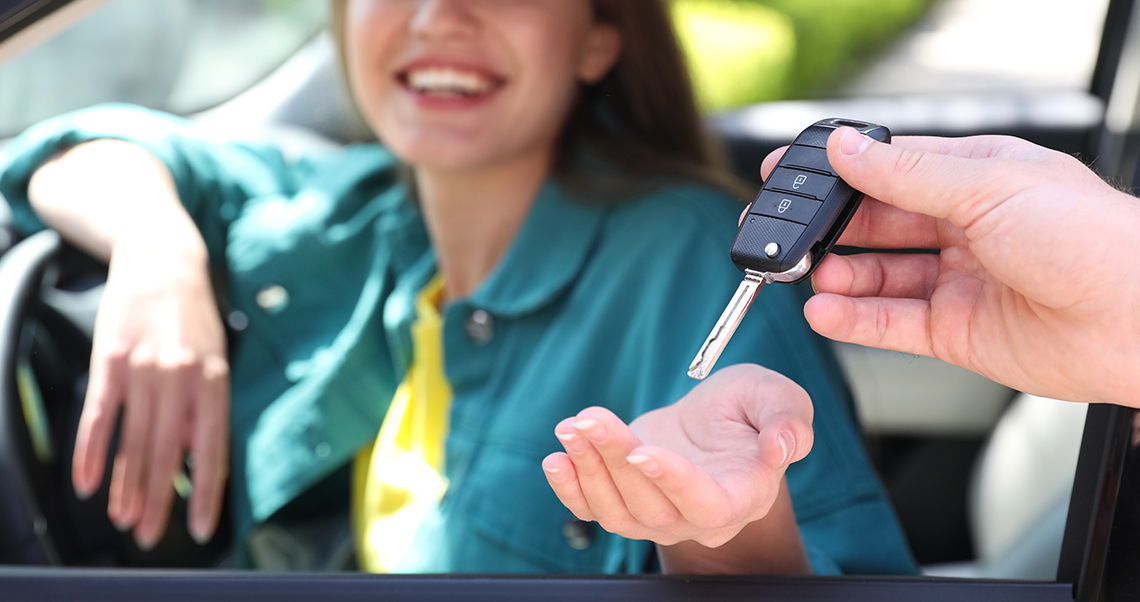 a person is giving a woman her car key