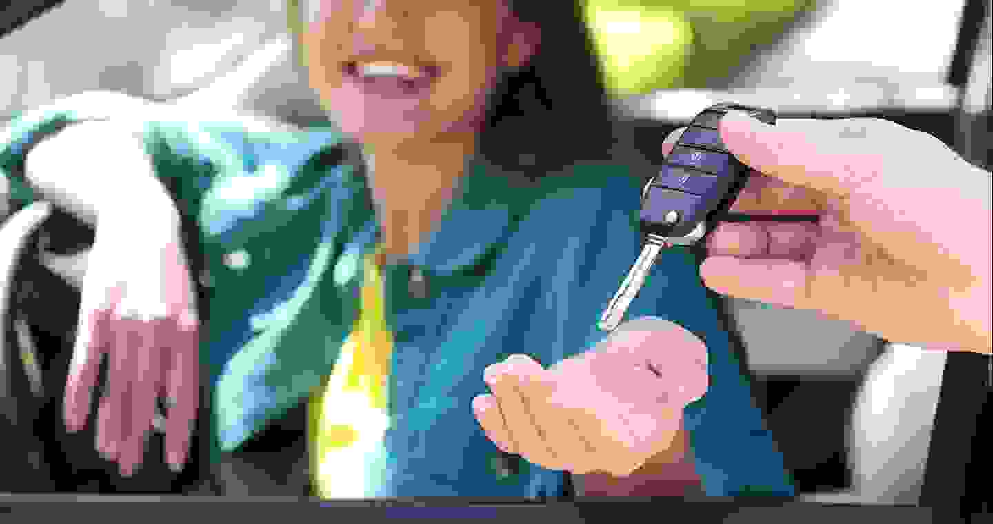 a person is giving a woman her car key