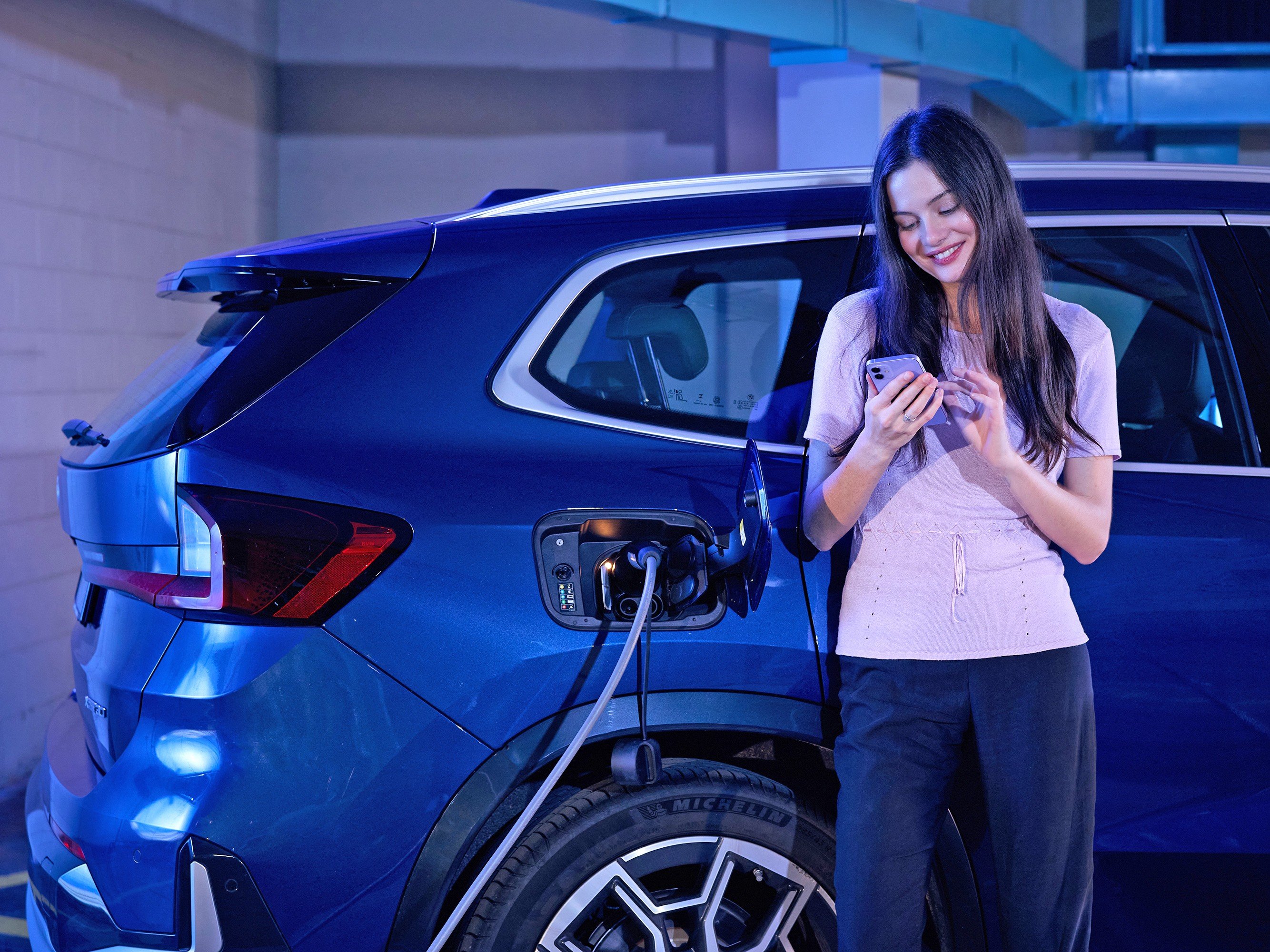 woman smiling while charging electric car