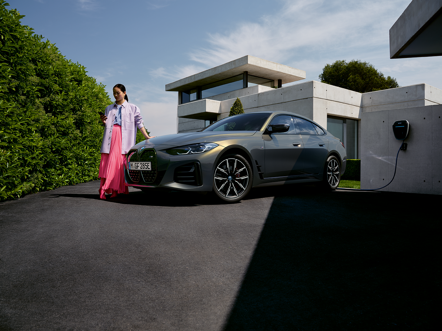 woman-leaning-on-bonnet-of-charging-bmw-ev.png