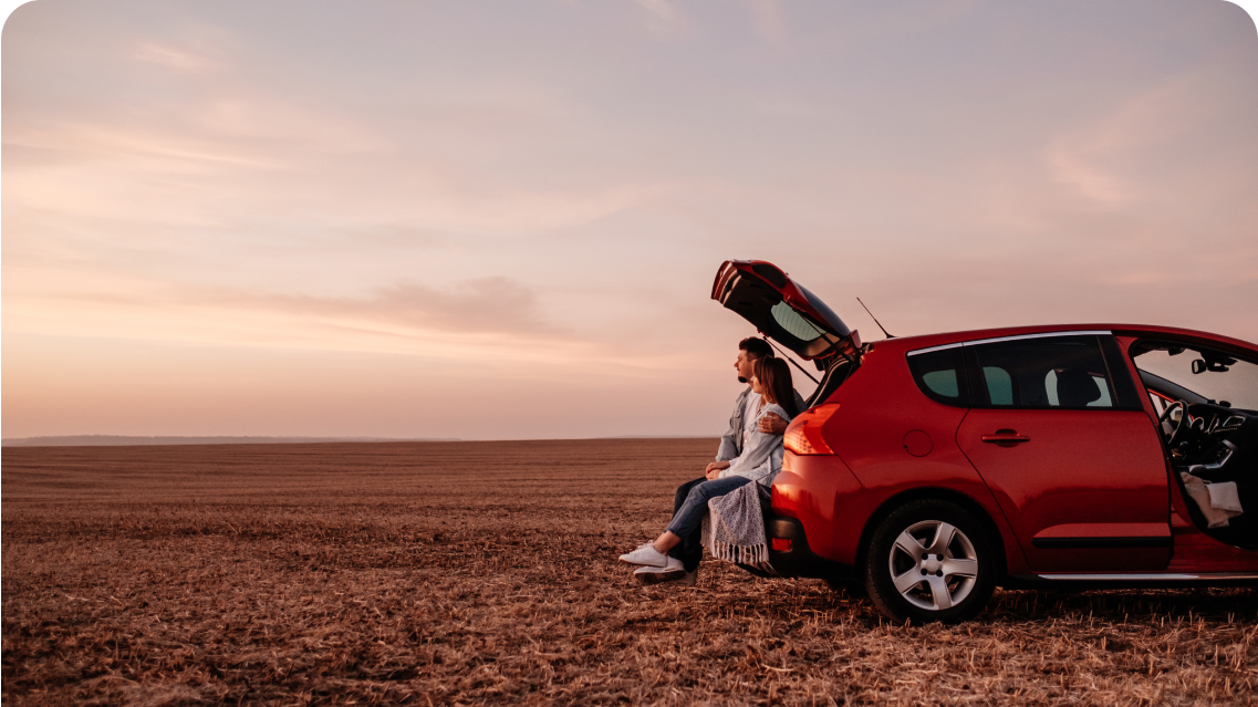 Family sitting in a car boot in an open landscape