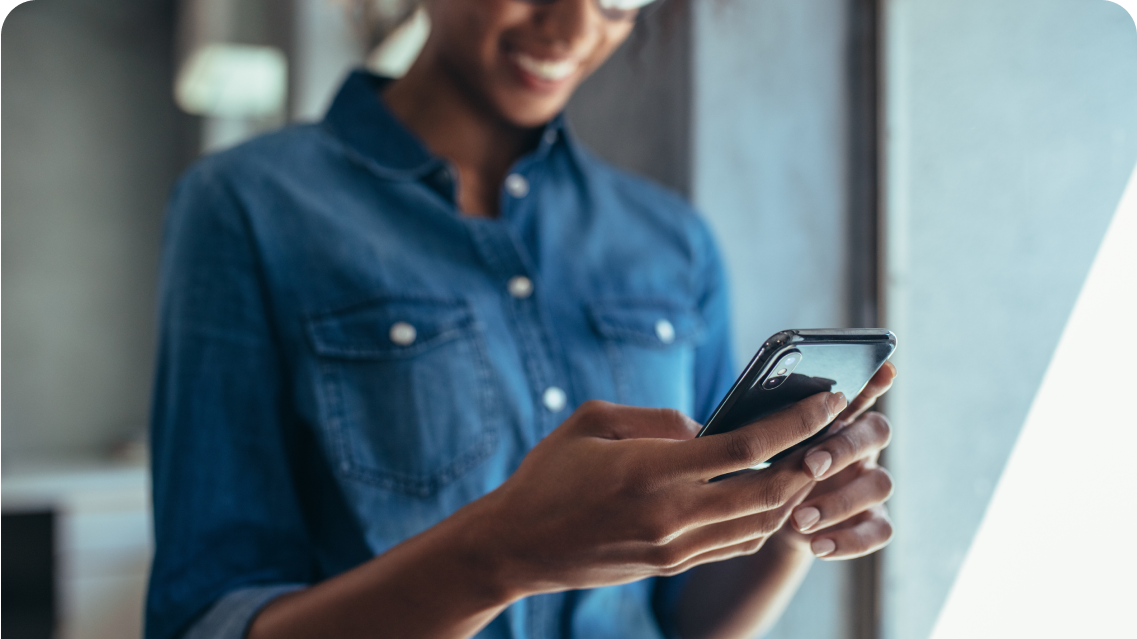 A woman smiling at her phone