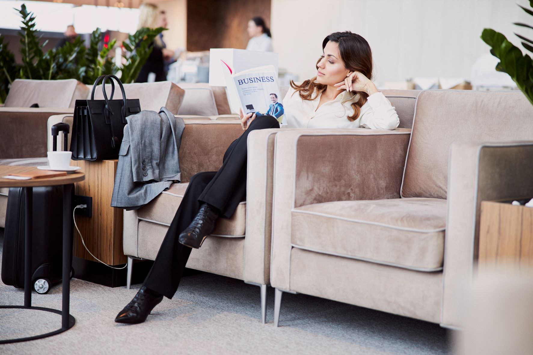 Women reading a magazine in an airport lounge