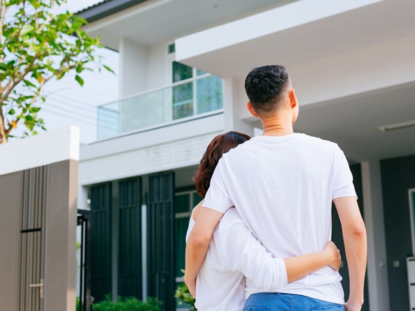 A happy couple looking at their house