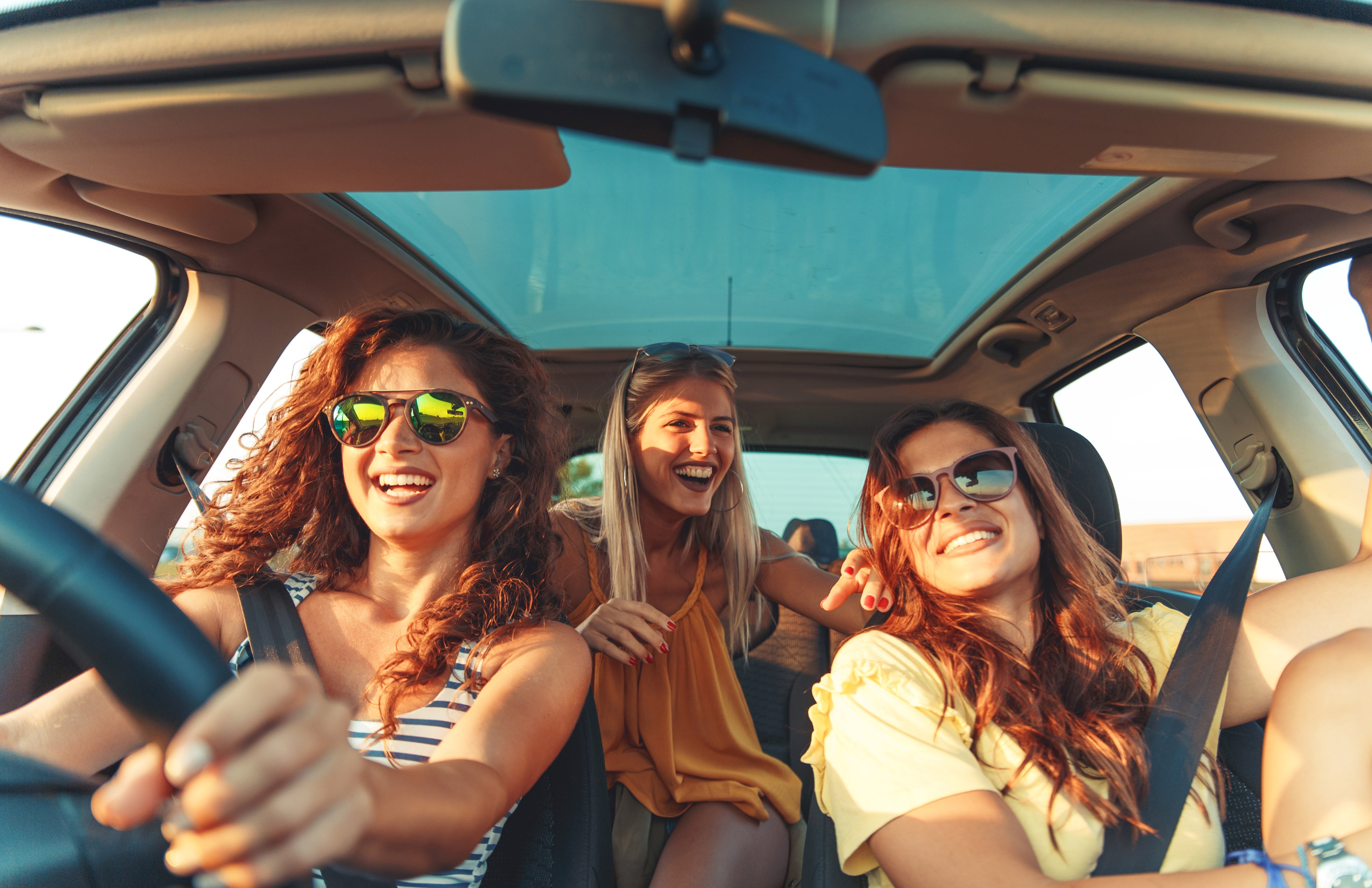 three-women-in-a-car-smiling-warm_ab313574721.jpg