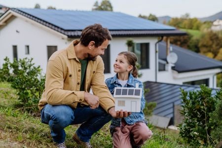 Adult and child with solar model outdoors