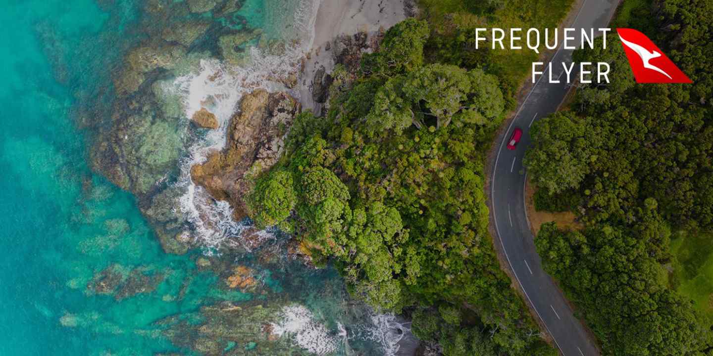 Aerial view of forest coast with red car